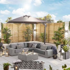Modern outdoor patio with sectional sofa, sun umbrella, potted plants, and decorative lanterns at Empire Home and Garden. Perfect for outdoor living and entertaining.