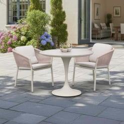 Modern outdoor patio dining set with white table and pink cushioned chairs, perfect for garden entertaining and outdoor living.