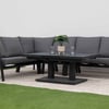 Modern outdoor living space featuring a stylish dark gray sectional sofa with black metal frame, perfect for garden patio lounging, complemented by a black coffee table, decorative potted plant, and vibrant red flowering plants.