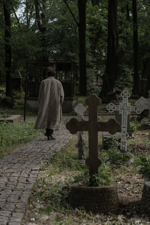 Karif Battle, founder of Theoretical Fiends LLC, got this photo, by Cottonbro Studio, from Pexels. In an old graveyard, riddled with craggy headstones, a man walks away, trench coat flapping in the breeze.