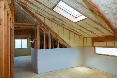 View of unfinished attic with exposed wall studs and insulation.