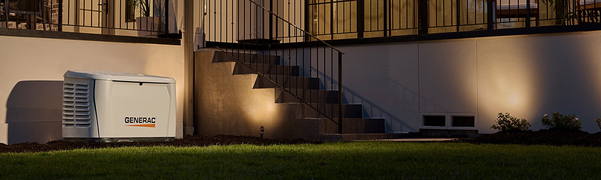 generac generator beside a home at night 