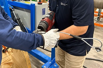 two people with a tool putting on wire pulling heads