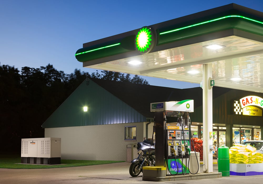 gas station lit up with a generac generator beside a building in the background