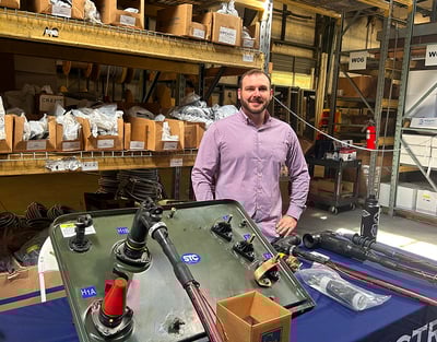 a man standing in a warehouse behind a table with electrical products
