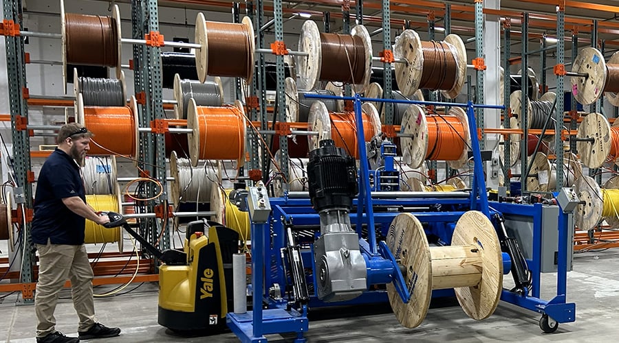 wire solutions warehouse with a man pushing a wire cutting machine