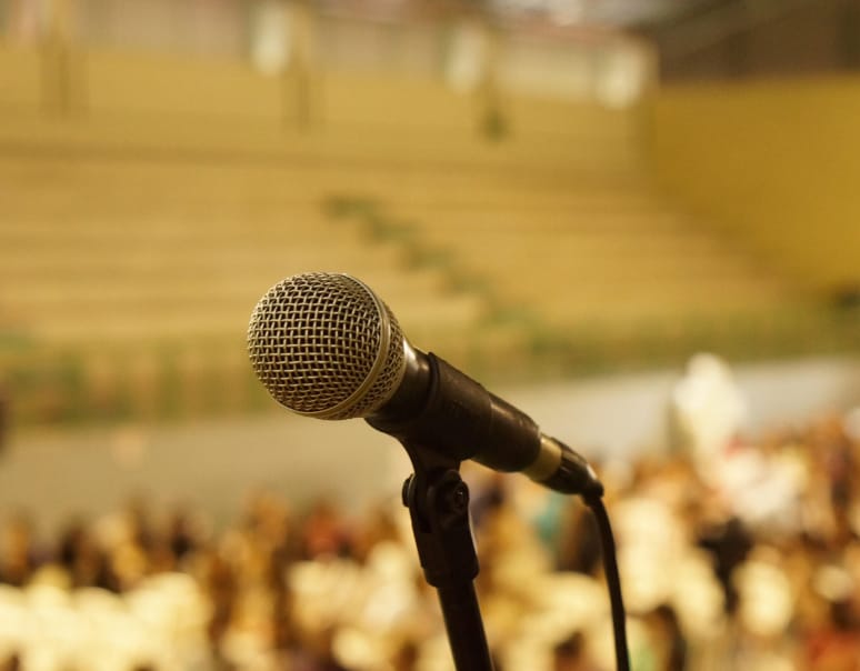 Photo of a microphone and blurred crowd