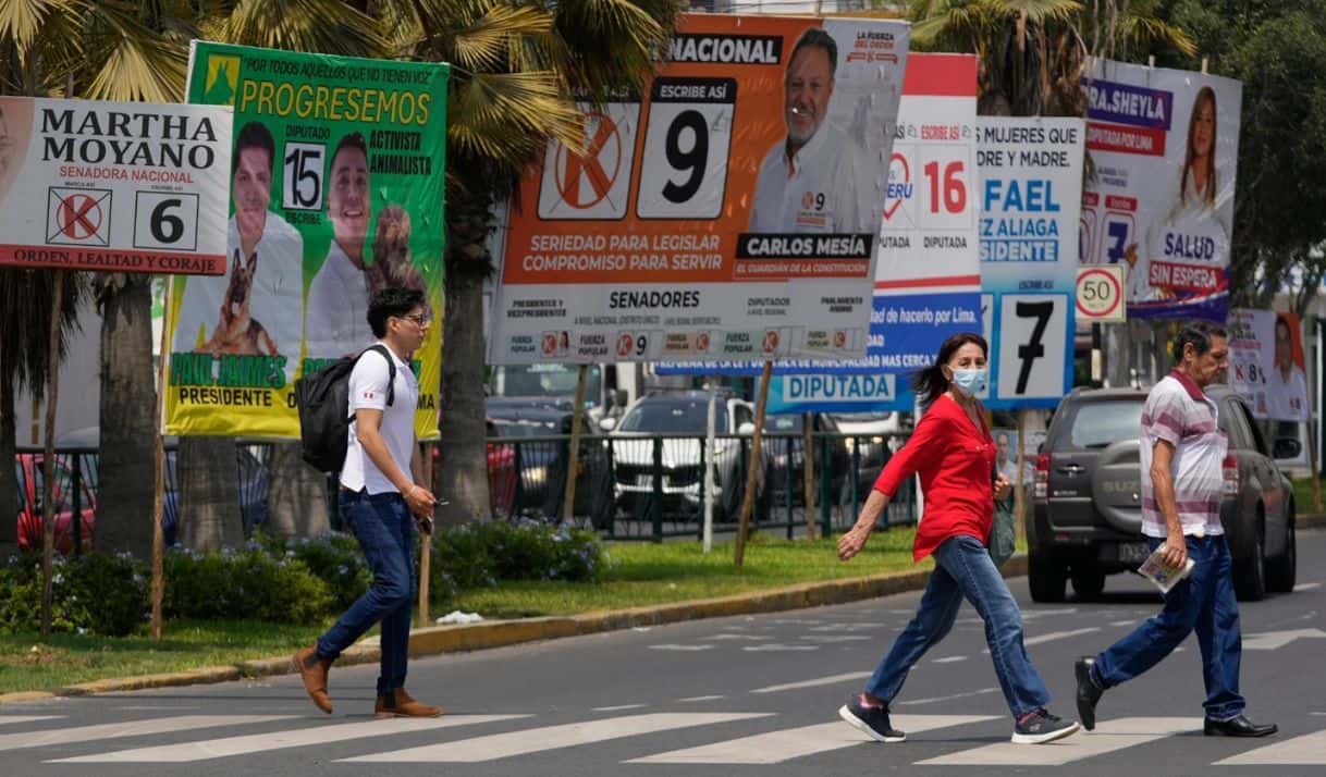 Peatones pasan junto a carteles de campaña electoral de candidatos presidenciales y congresistas, en Lima, Perú, el 10 de abril de 2026. (Foto AP/Martín Mejía)