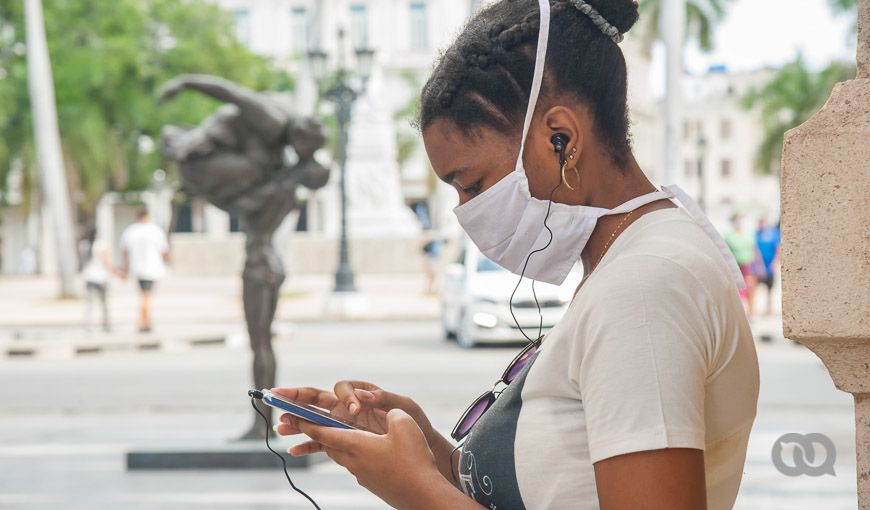 Muchacha de perfil conectada a Internet, Paseo del Prado La Habana Vieja, mascarilla, Cuba. Foto: El Toque