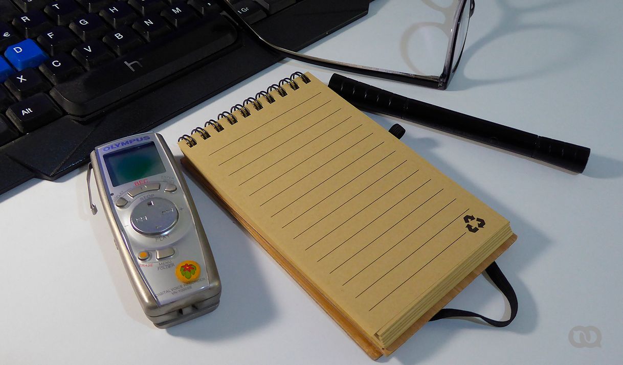 agenda, grabadora, espejuelo, bolígrafo, teclado, mesa