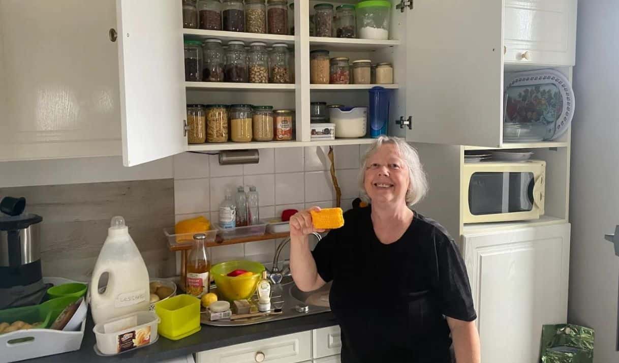 Andrée Nieuwjaer posa en su hogar en la ciudad de Roubaix, donde aprendió a reducir el desperdicio de alimentos. En su mano tiene una esponja que hizo con bolsas de papas no reciclables. Grist / Joseph Winters