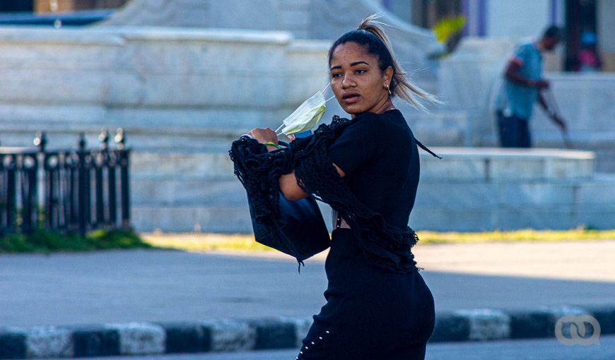 Chica remueve su mascarilla en el Parque de La Fraternidad. Foto: Sadiel Mederos (elTOQUE)