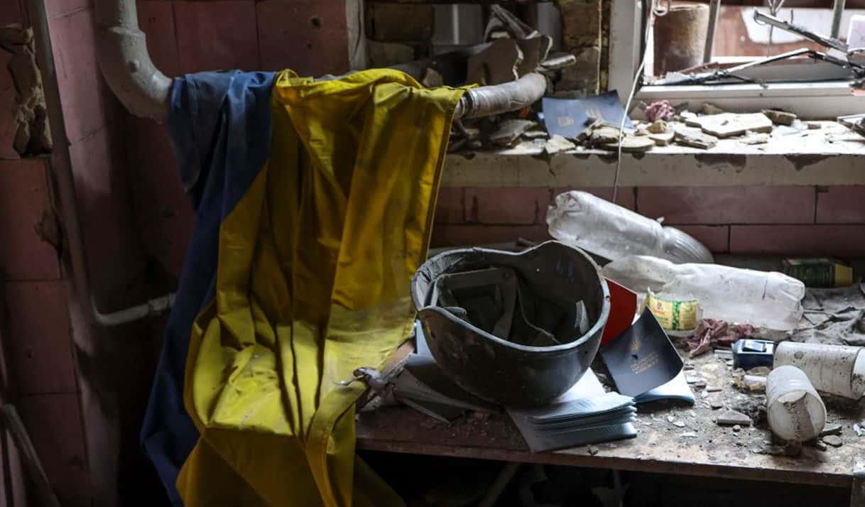 Una bandera ucrania, un casco militar y documentos médicos se ven sobre una mesa en una parte destruida de la planta metalúrgica Illich Iron & Steel Works, en Mariupol. Foto: Alexei Alexandrov / AP.