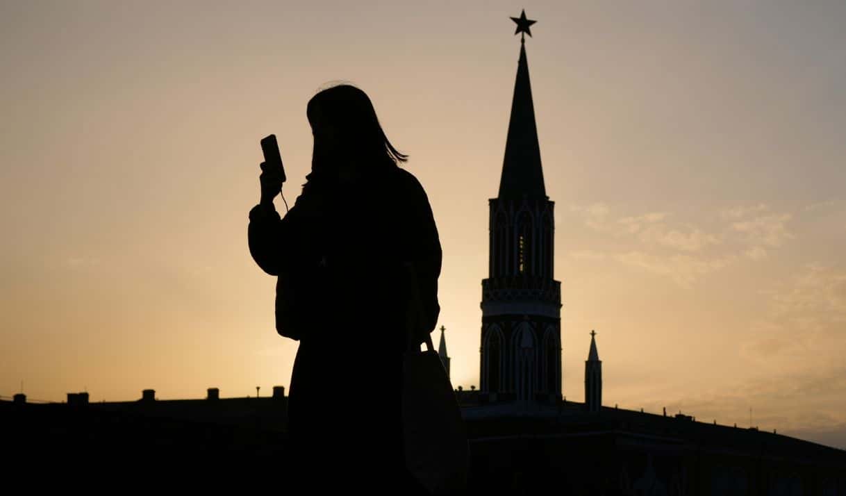 Imagen de referencia / Una mujer comprueba su celular mientras camina por la plaza Roja al atardecer, en Moscú, el martes 31 de marzo de 2026. AP Foto/Pavel Bednyakov, Archivo.