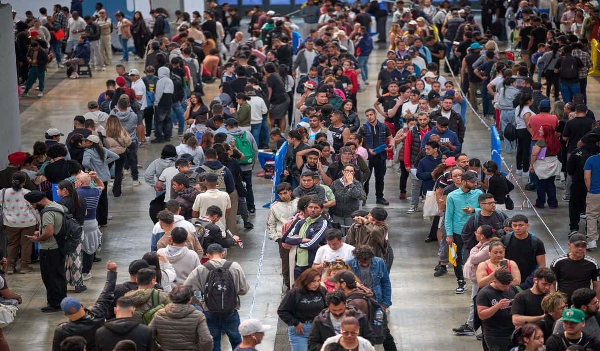 Migrantes hacen fila en una oficina institucional para obtener documentación de cara a regularizar su residencia en España, en L'Hospitalet de Llobregat cerca de Barcelona, España, el 21 de abril de 2026. (AP Foto/Emilio Morenatti)