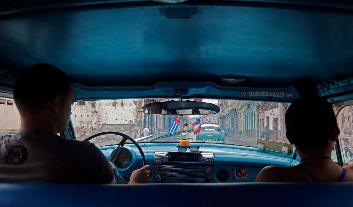 Un taxista lleva colgadas banderas de Cuba y Estados Unidos en su vehículo en La Habana, Cuba, el viernes 16 de enero de 2015, en un recordatorio del acuerdo entre ambos países para normalizar sus relaciones.(AP Foto/Desmond Boylan)