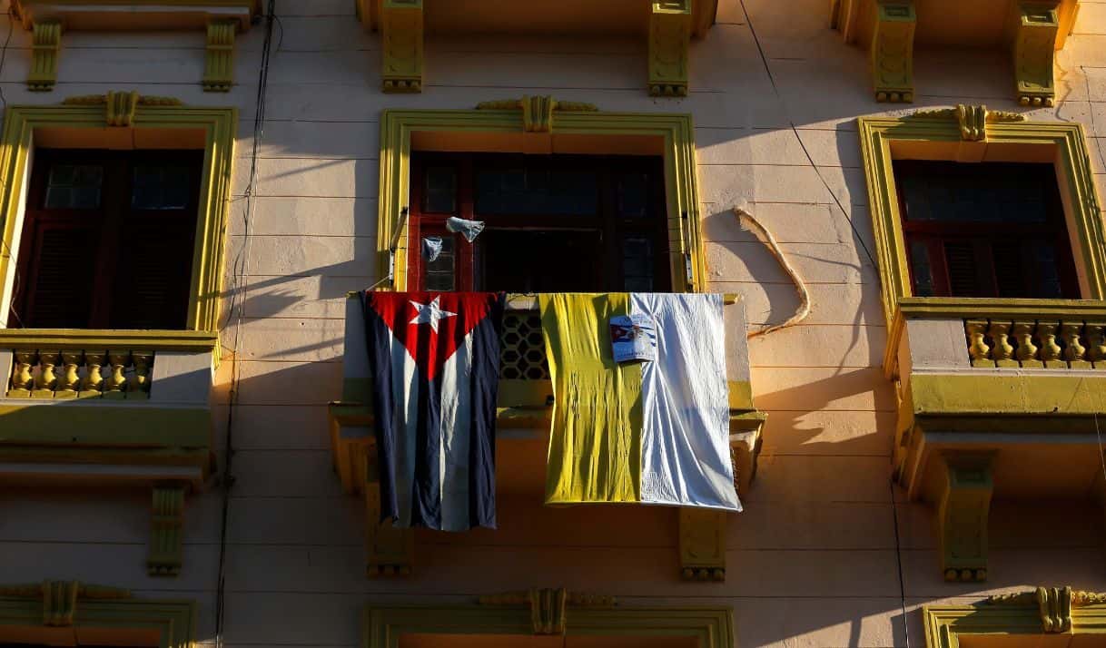 Las banderas de Cuba y El Vaticano cuelgan de un balcón en la calle Reina de La Habana, Cuba, el sábado 19 de septiembre de 2015, antes de la llegada del papa Francisco. (Foto AP/Desmond Boylan)