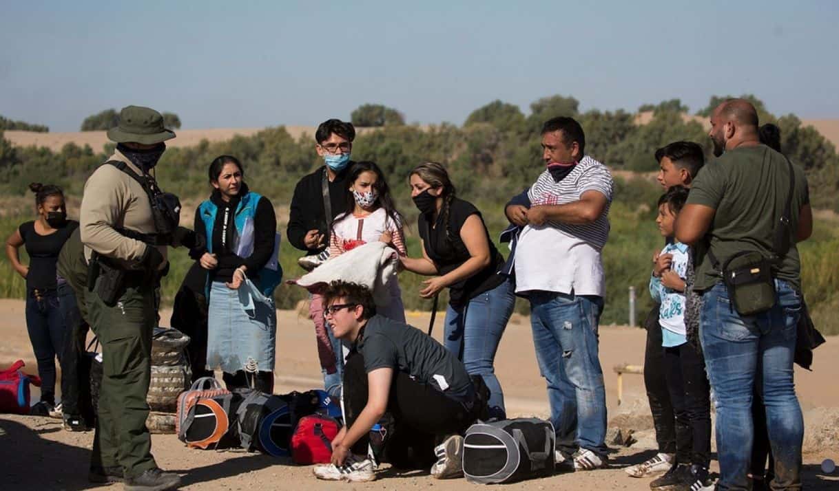 Migrantes esperando ser procesados por los oficiales de emigración. Foto: Ringo Chiu/Shutterstock.
