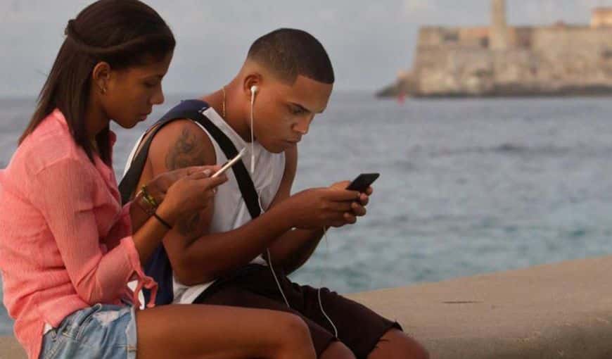 Jóvenes conectándose a internet desde el malecón de La Habana. Foto: EFE. 