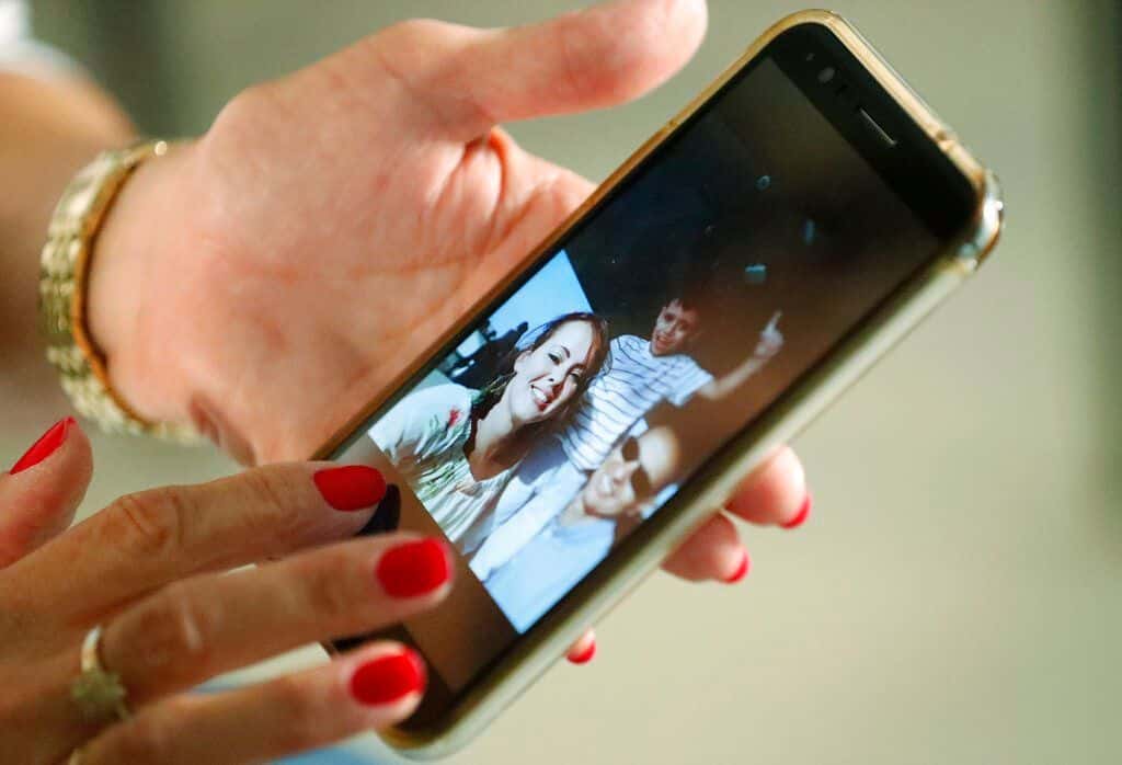 En esta imagen, tomada el 20 de junio de 2019, Mary Sardinas, de 60 años, muestra una fotografía de su hijo, su nuera y su nieto en Cuba durante una entrevista con The Associated Press en Miami. Sardinas es una de los miles de cubanos que viven en Estados Unidos cuyos sueños de reunirse con sus familiares han quedado en suspenso desde septiembre de 2017, cuando el gobierno de Donald Trump retiró a gran parte del personal de la embajada de La Habana en respuesta a incidentes de salud que afectaron a unos 26 funcionarios y sus familias. (AP Foto/Wilfredo Lee)
