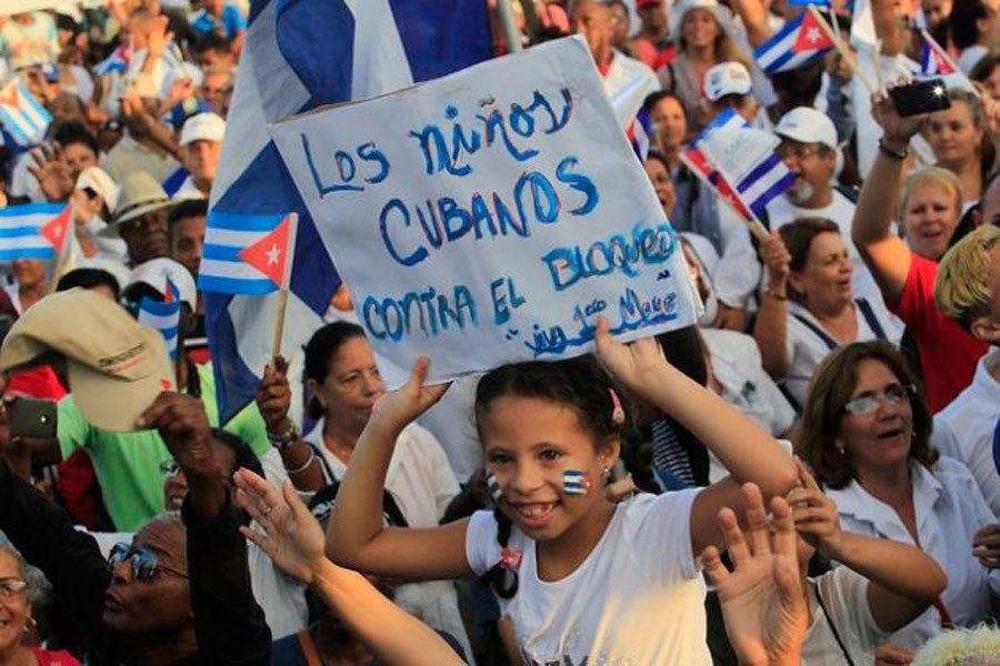 Durante un acto público en La Habana, una estudiante de educación primaria sostiene un cartel donde se lee: “Los niños cubanos estamos contra el bloqueo”, en alusión a las nuevas sanciones económicas y financieras impuestas por la administración estadounidense de Donald Trump a Cuba este año. Foto: Jorge Luis Baños/ IPS
