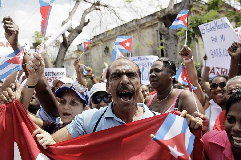 Personas en un acto o mitin de repudio con banderas cubanas en Cuba año 2016, grito, calle. Acto de repudio en Cuba, 2016. Foto: CubaEncuentro.