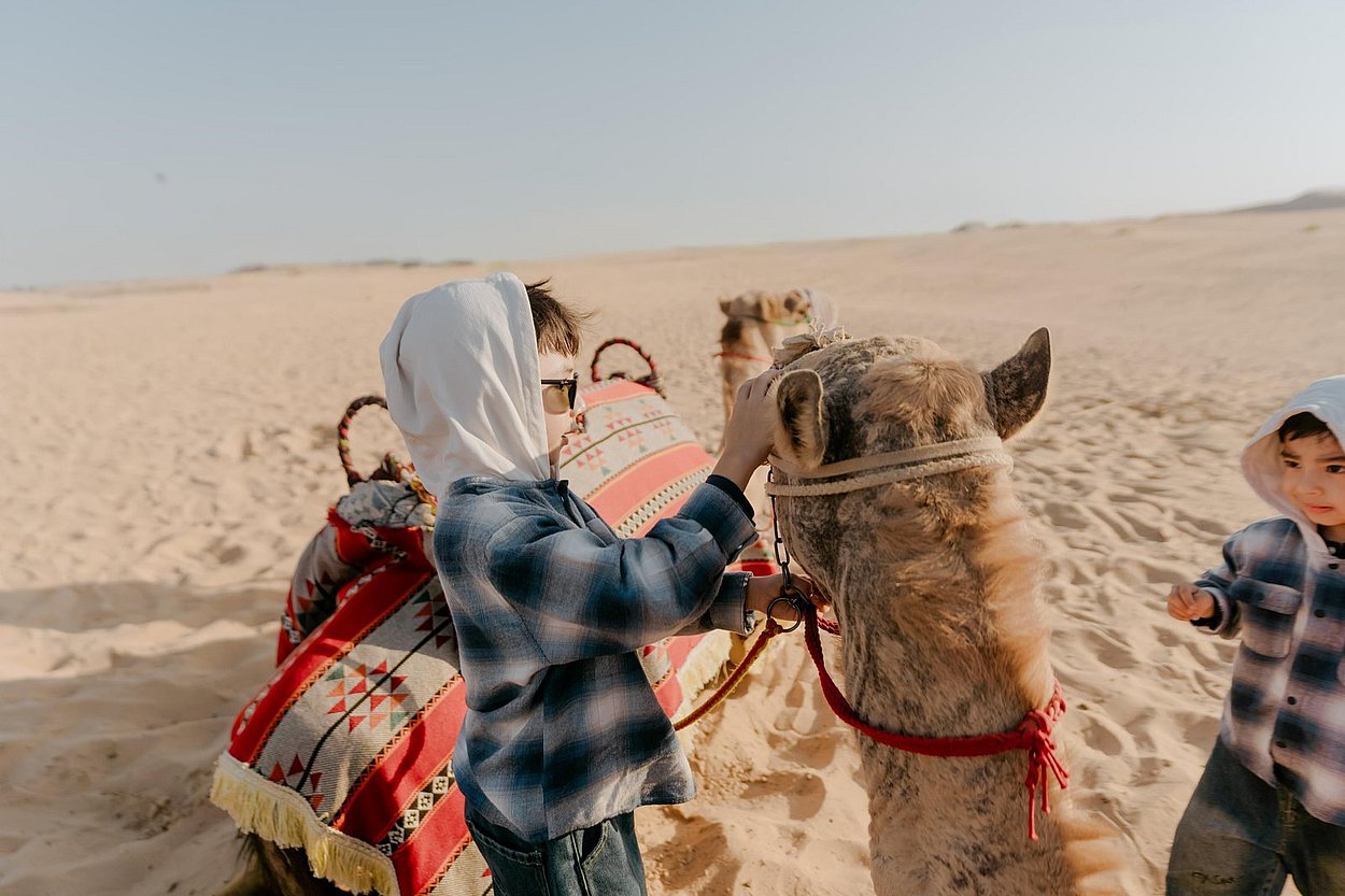 Kids camel ride Abu Dhabi desert safari tour