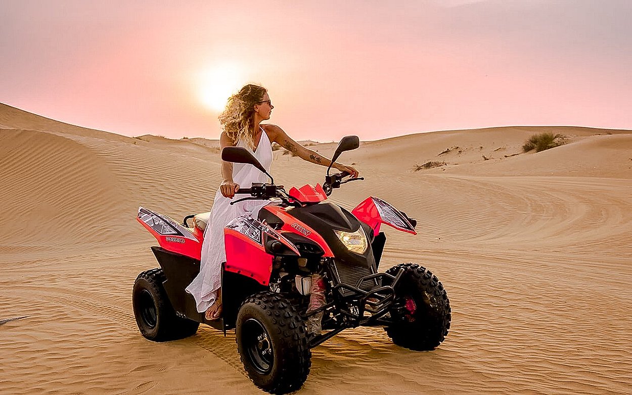 Quad bikes arranged on the desert sand in Abu Dhabi during a sunset quad biking tour