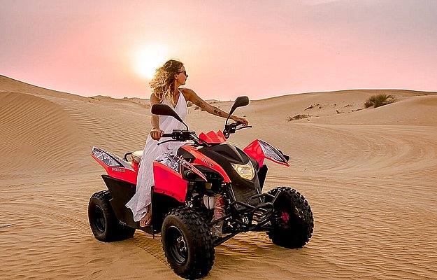 Quad bikes arranged on the desert sand in Abu Dhabi during a sunset quad biking tour