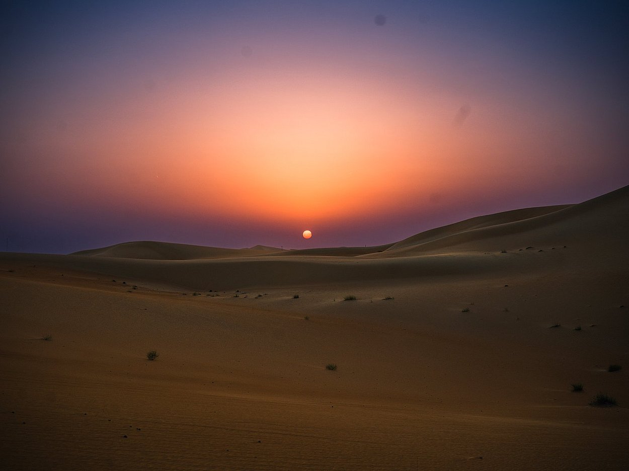 Beautiful sunset over Al Quaa desert dunes during night desert safari tour in Abu Dhabi