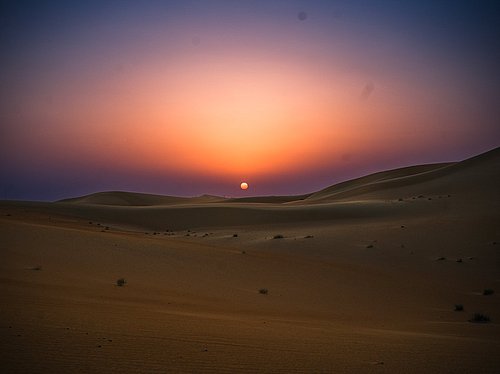 Beautiful sunset over Al Quaa desert dunes during night desert safari tour in Abu Dhabi
