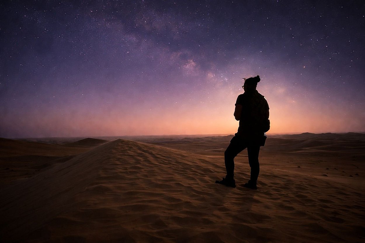 Stargazer standing on desert dunes during Al Quaa Milky Way Night Desert Safari Tour Abu Dhabi