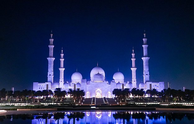 Sheikh Zayed Grand Mosque illuminated with night reflections