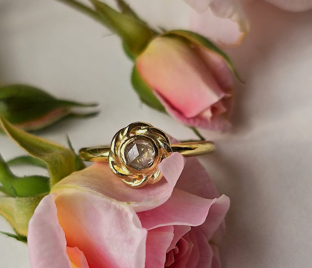 Rose Cut Diamond ring in 18ct gold displayed on pink rose