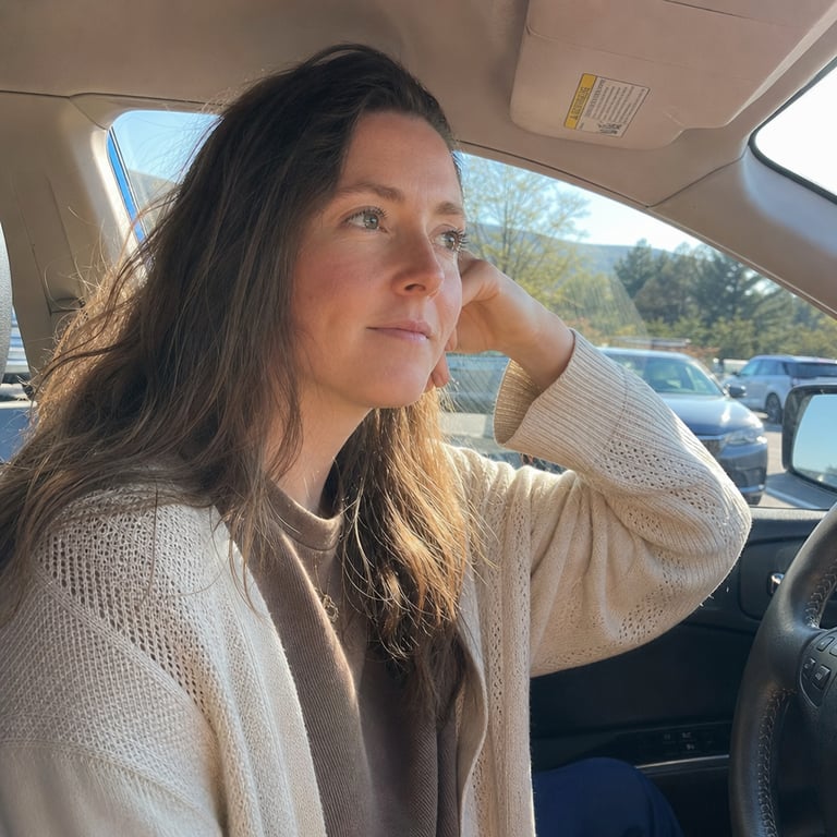 Woman in car, looking out window in thought