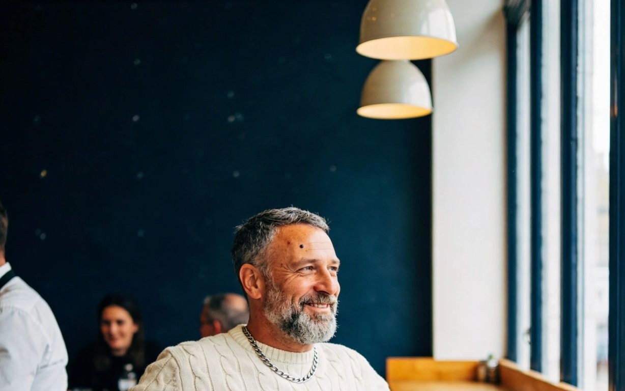 A man in a cafe by the window, considering