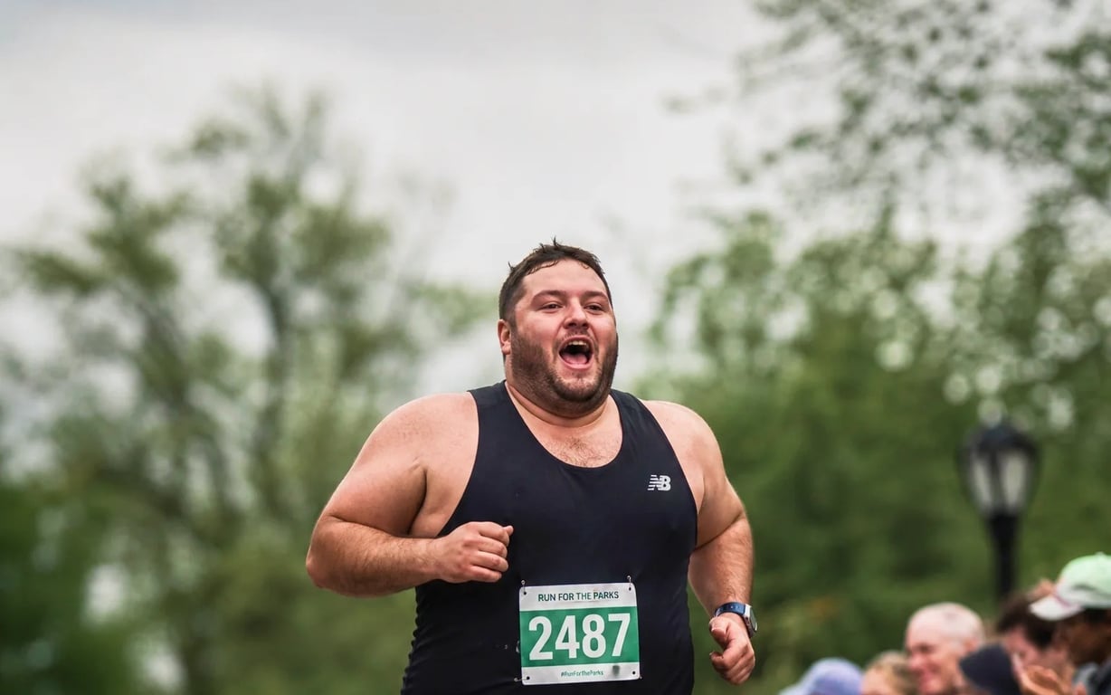 A man running a park race, mid-stride