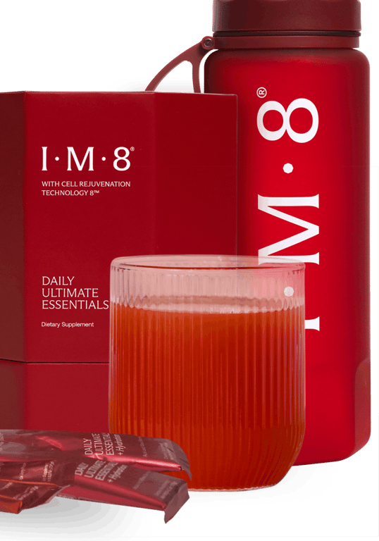 The IM8 Daily Ultimate Essentials carton beside a mixed glass and the signature red bottle