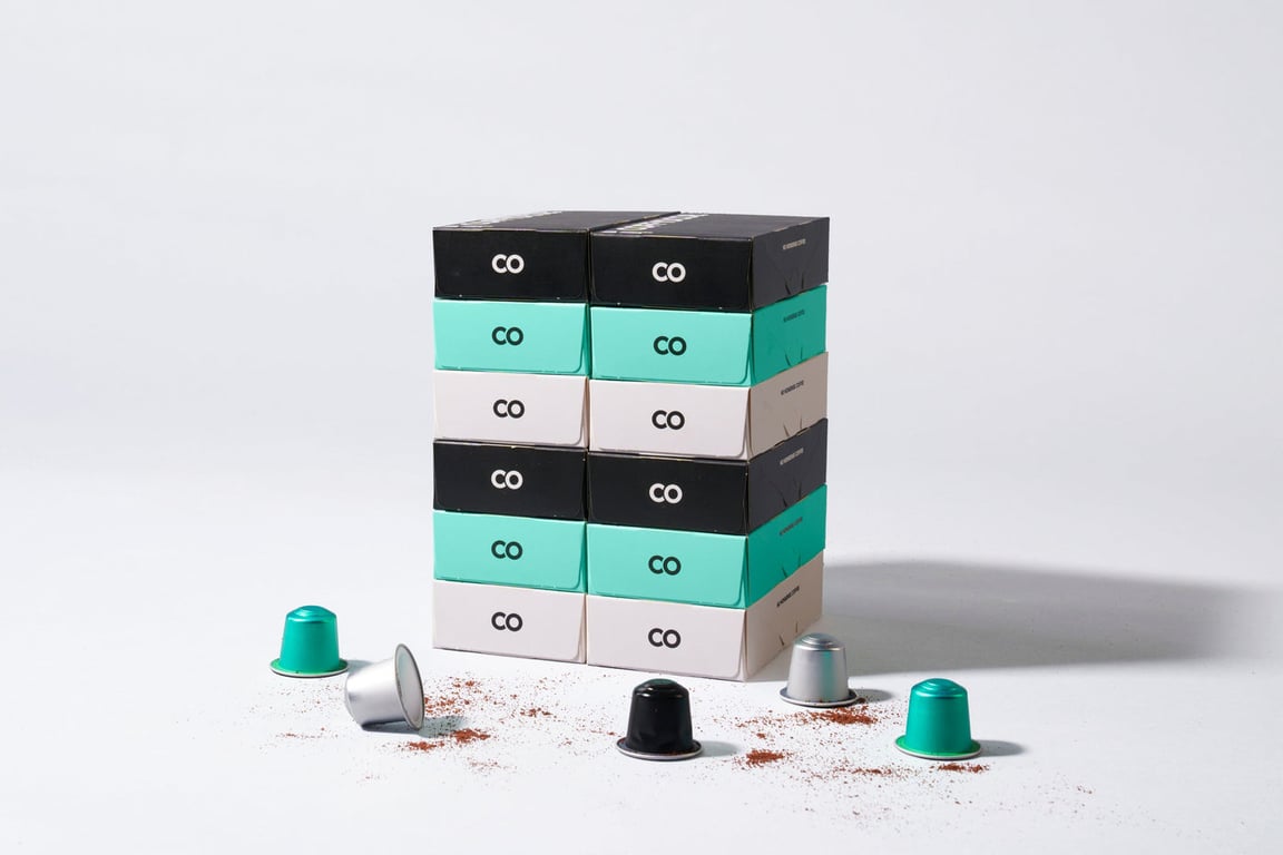 Coffydoor capsules in mint, black and silver on a kitchen counter