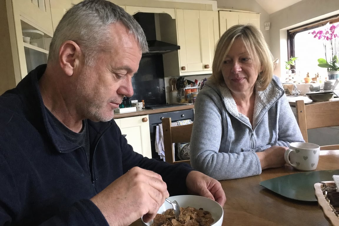 A couple in their sixties having breakfast together at their kitchen table