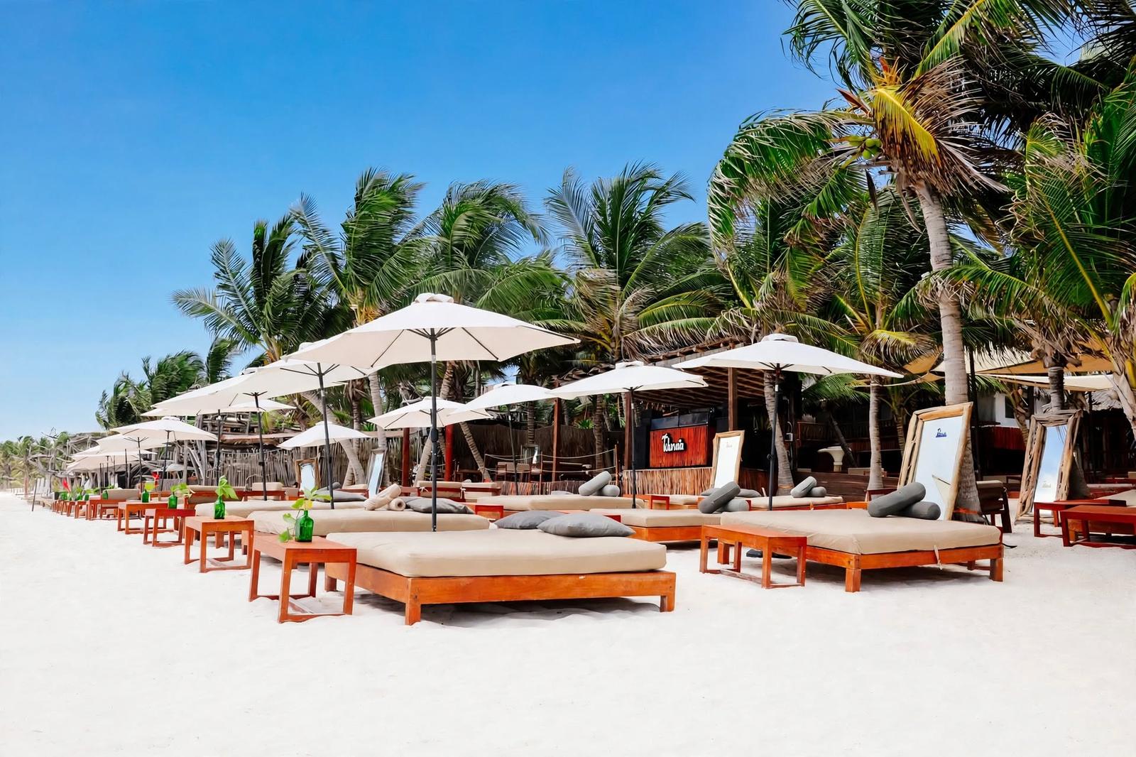 Tulumania’s beachfront deck has lounge beds, umbrellas, palm trees and a bright, relaxed atmosphere.