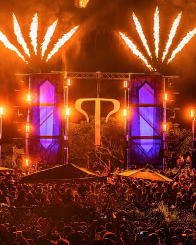 templo stage with purple panels, fire effects, and a large crowd under orange lighting.