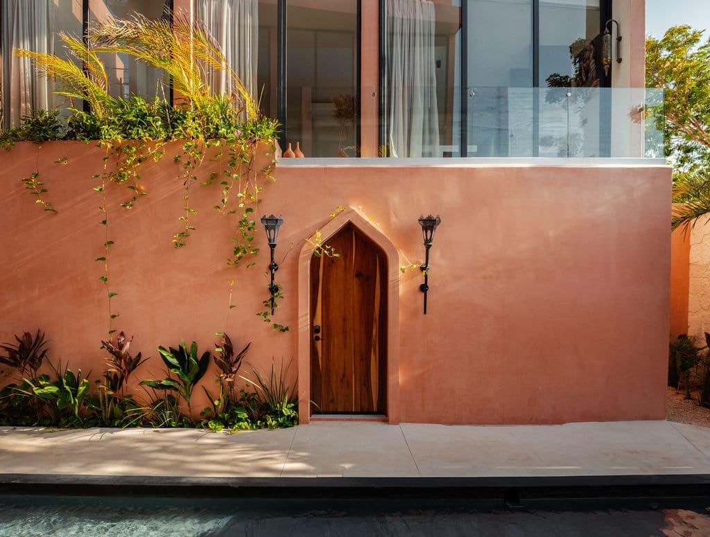 Arched timber door in a lime-plaster wall