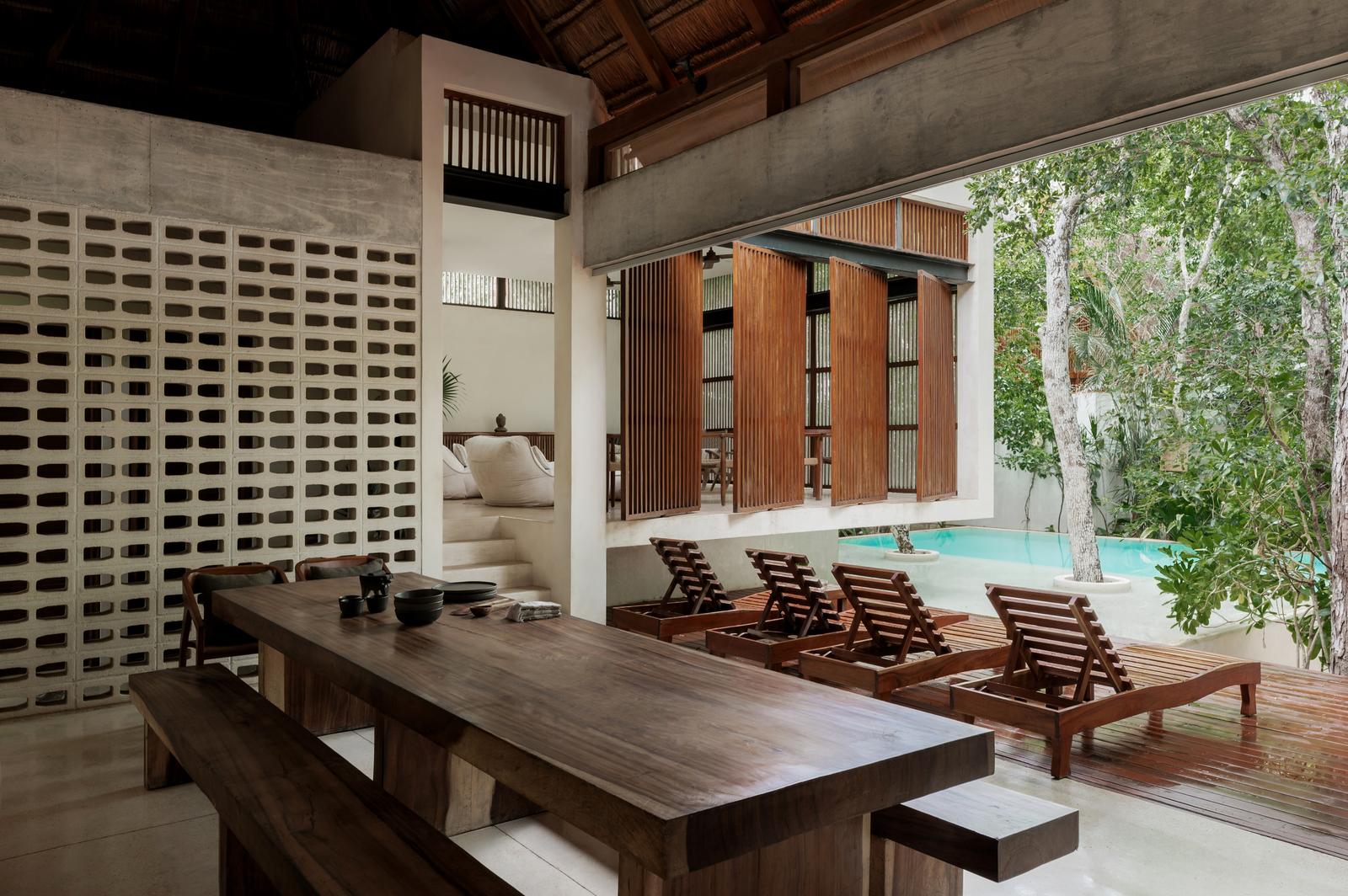 Outdoor dining table and loungers by the pool