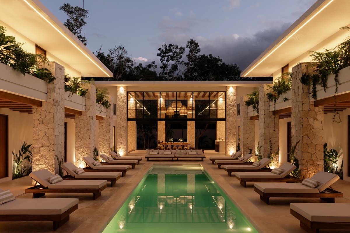 The courtyard pool at dusk, lit along both wings