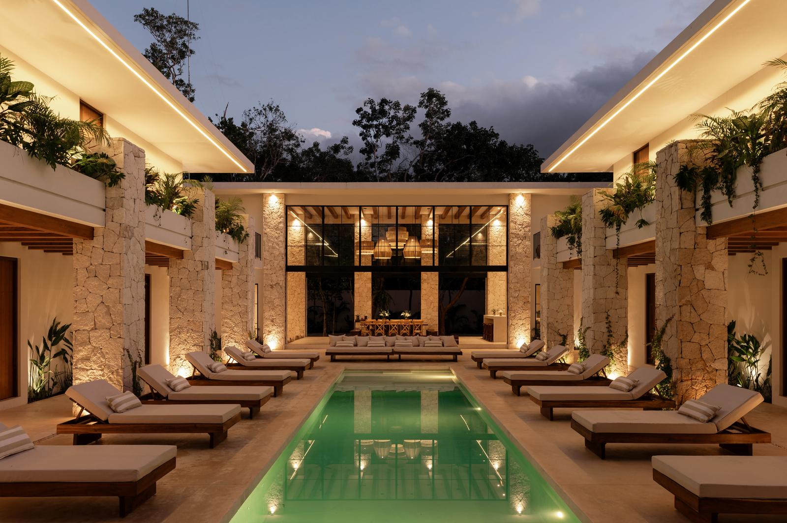 The courtyard pool at dusk, lit along both wings