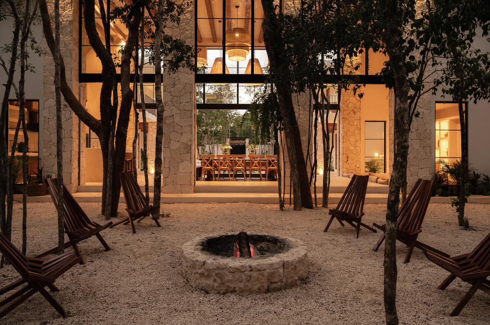 The firepit with the house lit behind it