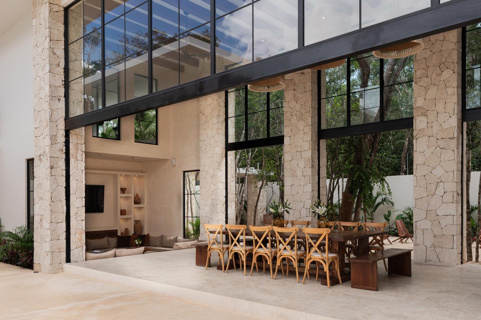 Double-height living room behind a full glass wall