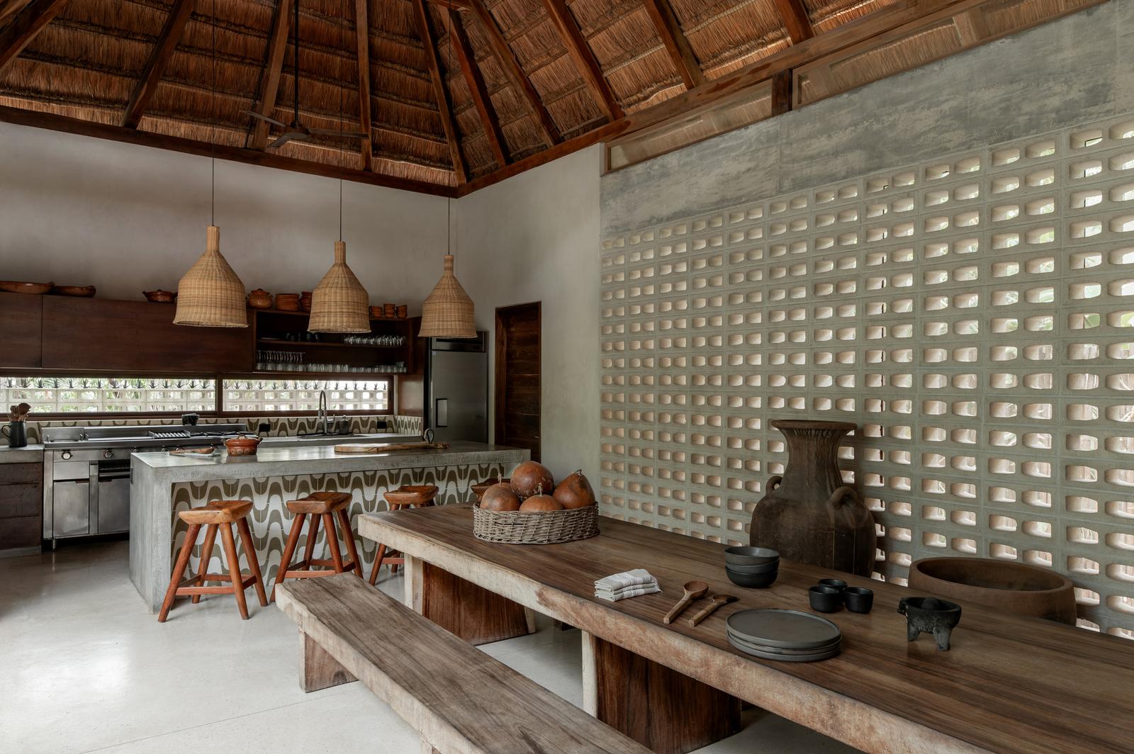 Chef's kitchen under the palapa roof, with the long dining table