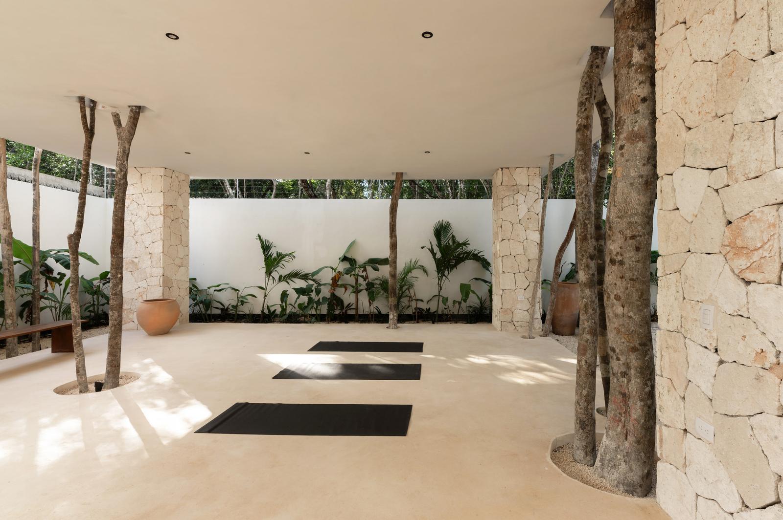 Yoga room, mats laid out between the stone columns